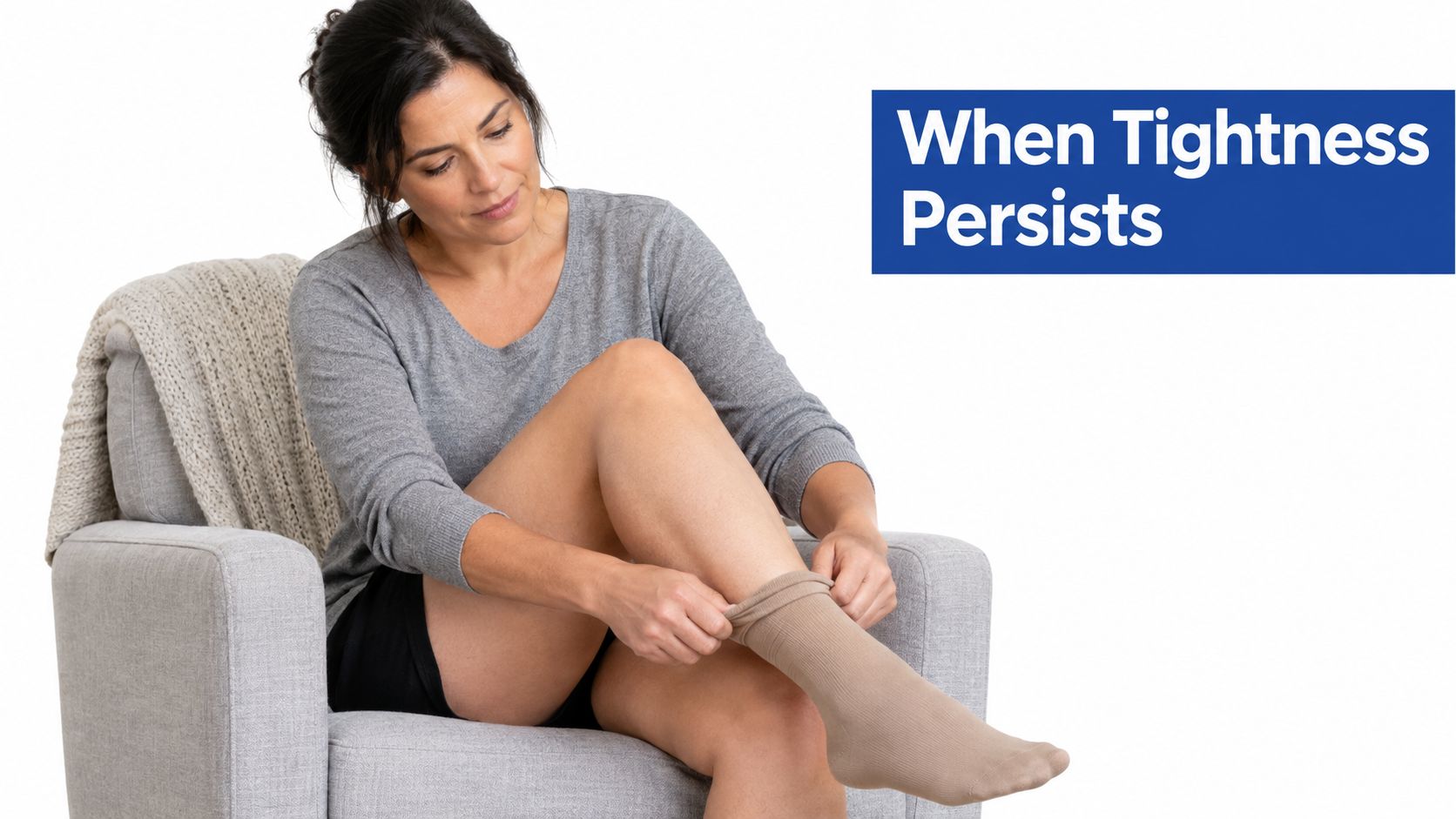 A woman sitting in a chair putting on a compression sock to address tight skin on legs.